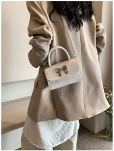 Elegante borsa a tracolla bianco crema con fiocco in metallo e manico superiore