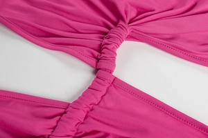 Detail of rose pink dress featuring elegant twist pleats and central cutout design