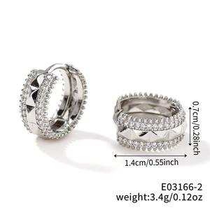 Macro shot of silver-tone hoop earrings with micro-paved zircons and pyramid studs details
