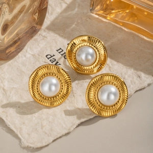 Détail de boucles d'oreilles perles dorées vintage avec bordures texturées sur papier