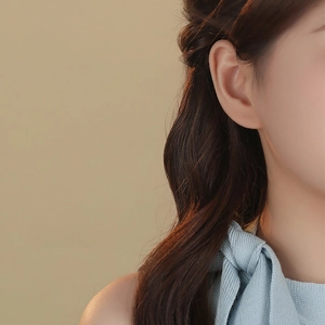 Mini S999 sterling silver bow stud earring shown on a model for a delicate minimalist look