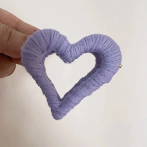Detailed view of a purple plush heart-shaped hair claw clip with wool texture finish