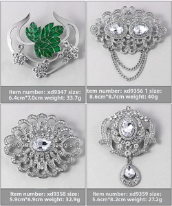 Detailed comparison of four vintage silver brooches with crystal rhinestones and enamel leaves