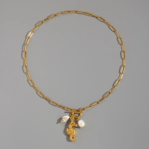 Detail of 18K gold seahorse necklace with white baroque pearl and shell on paperclip chain