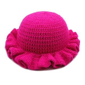 Close-up of rose red hand-crocheted knit hat featuring elegant ruffled brim texture