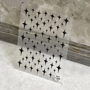 Detail showing 5D embossed black starburst nail stickers with 3D texture on clear sheet