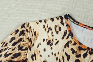 Detail of round neckline and leopard print fabric with elastic stitching on long sleeve dress