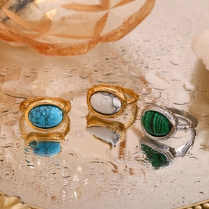 Vue détaillée de bagues en acier inoxydable doré 18 carats et pierres naturelles sur miroir