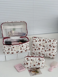 Three-piece floral corduroy cosmetic bag set with red zippers on white display stand
