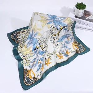 Detail of silk-like neck scarf with cashew floral pattern on cream base and magazines