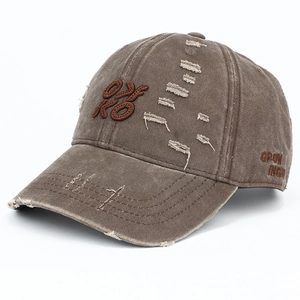 Detailed macro of vintage washed brown cotton baseball cap with distressed hole effects