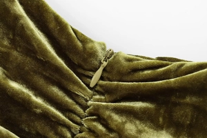 Macro shot of olive green velvet fabric texture featuring a seamless invisible zipper detail
