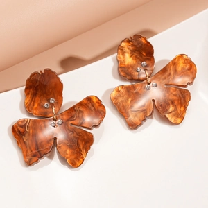 Detail of amber resin leaf earrings with sparkling rhinestone accents and gold link