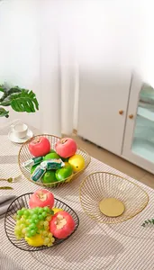 Detail of wave-edge wire fruit basket in gold and black finishes for home storage