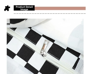 Detail of a black and white checkerboard canvas tote with a white zipper and silver puller