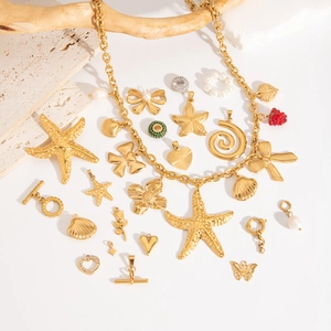 Close-up of golden starfish and heart pendants with pearls on a decorative stone base