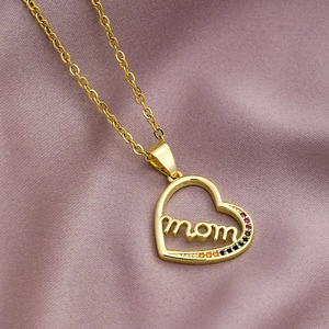 Detailed view of a gold heart pendant with Mom lettering and colorful zircons on silk