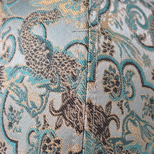 Macro detail of Chinese dragon embroidery on jacquard fabric baseball cap texture