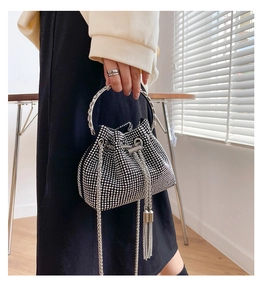 Detail of black rhinestone bucket bag with silver tassels and metal ring handle