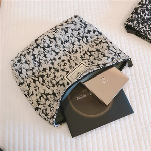 Detailed close-up of a floral jacquard makeup bag with a zipper and textured fabric