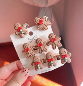 Set of eight cute resin gingerbread man hair clips on a display card with bows