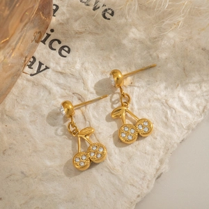 Chic gold cherry stud earrings with sparkling rhinestones on textured paper background