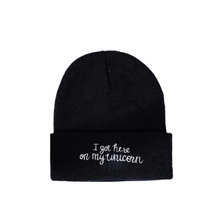 Classic black knitted beanie hat with white unicorn phrase embroidery on cuff