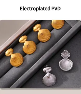 Detail of PVD electroplated gold and silver shell earrings on a jewelry display tray
