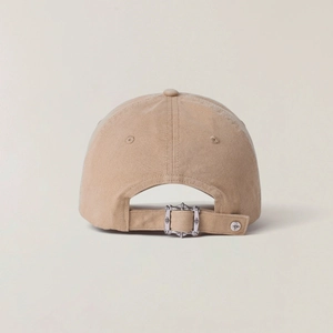 Detail of khaki cotton baseball cap back with vintage carved metal buckle and cross stud