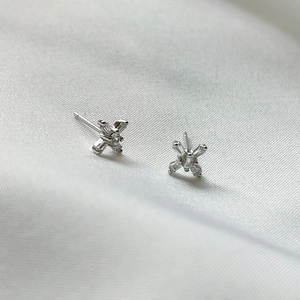 Close-up of 925 sterling silver cross stud earrings with sparkling baguette-cut zircons