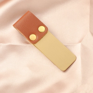 Dettaglio della clip per penna vintage in pelle marrone e metallo spazzolato oro