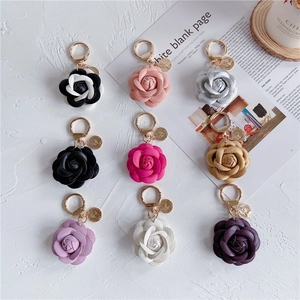 Nine color options of camellia leather keychains with gold metal clasps and coin charms