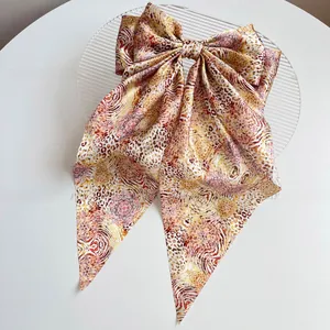Detail shot of large leopard print bow hair clip with silky long ribbon streamers