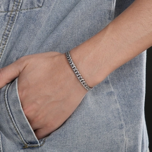 Silver stainless steel Cuban link bracelet on wrist with a classic hip-hop style design