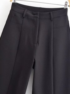 Détail du pantalon de costume noir avec passants de ceinture et texture sergée fine