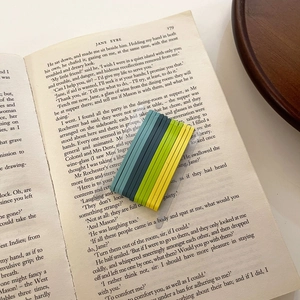 Close-up of 30 gradient candy-colored metal hairpins neatly arranged on Jane Eyre book pages