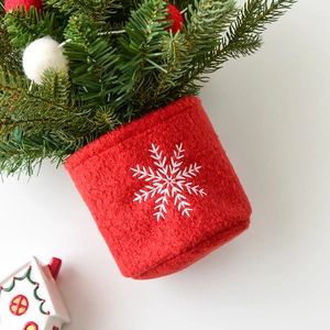 Mini Christmas tree with red wool felt base featuring white snowflake embroidery and ornaments
