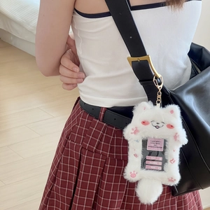 Plush white kitten card holder with pink paw detail hanging on a black crossbody bag