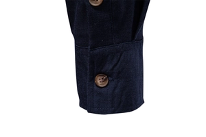 Detailed macro view of dark blue shirt cuffs with premium brown button and stitching