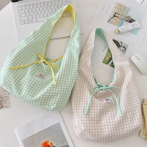 Close-up of checkered seersucker tote bags in green and pink with bow tie details