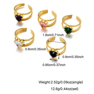 Detailed view of five gold twisted open rings with colorful heart-shaped zirconia stones