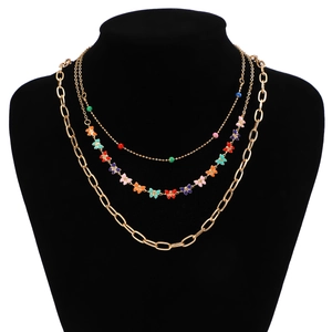 Detail of layered gold-tone necklace featuring colorful butterfly pendants and beaded chain