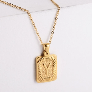 Macro detail of 18K gold-plated rectangle pendant with embossed letter Y on O-chain