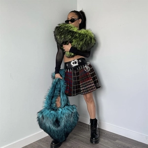 Detail of teal heart-shaped faux fur crossbody bag styled with trendy outfit