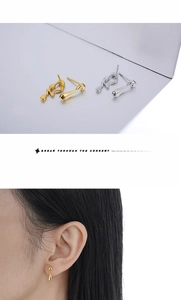 Detail of silver and gold irregular teardrop earrings featuring modern fluid metal design