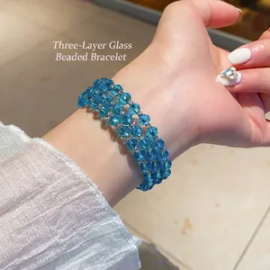 Three-layer blue faceted glass bead bracelet with metal spacers shown on female wrist