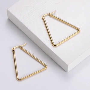 Minimalist gold-finished stainless steel triangle hoop earrings on a white display block