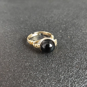 Handmade gold wire wrapped ring featuring a large polished black natural stone crystal