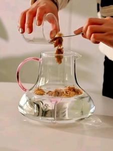 Detail of high borosilicate glass teapot with pink handle brewing herbal flower tea