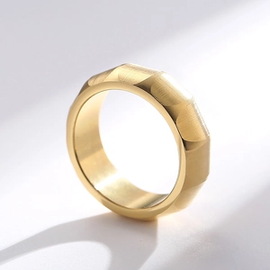 Macro detail of 18k gold matte titanium ring with geometric facets and brushed metal finish